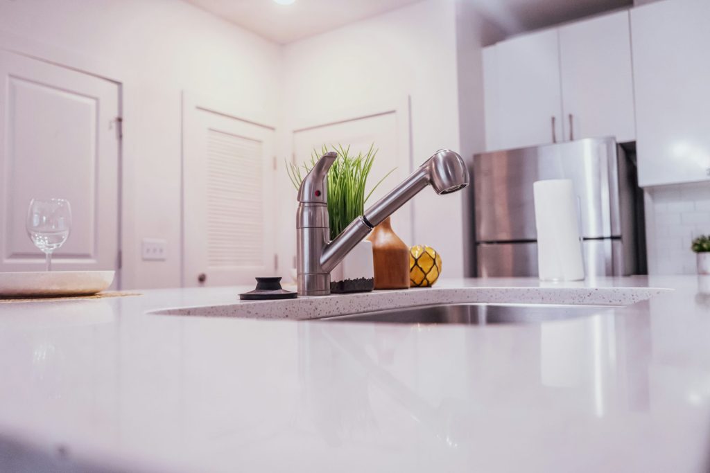Una encimera de cocina con un fregadero y una planta en maceta.